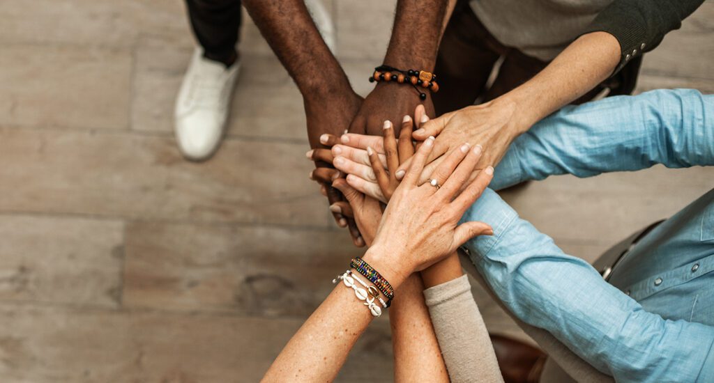 Multiple hands stacked in collaboration.