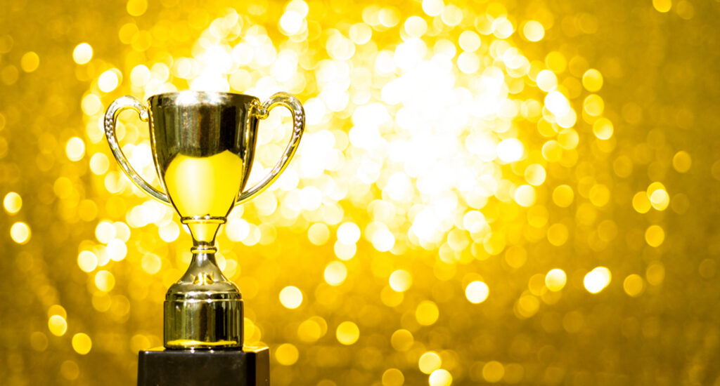 Shiny trophy against golden background.