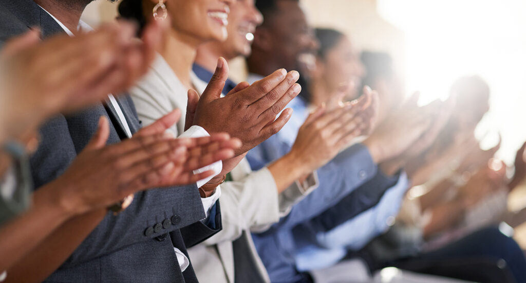 Cropped shot of an unrecognizable diverse group of businesspeople applauding while sitting in the boardroom during a presentation Audience applauding in a gathering.