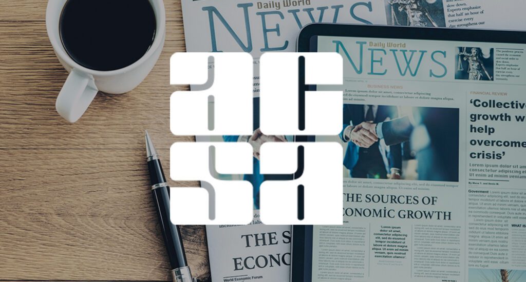 Desk with coffee cup, newspaper and tablet showing digital newspaper, with ACSA logo.